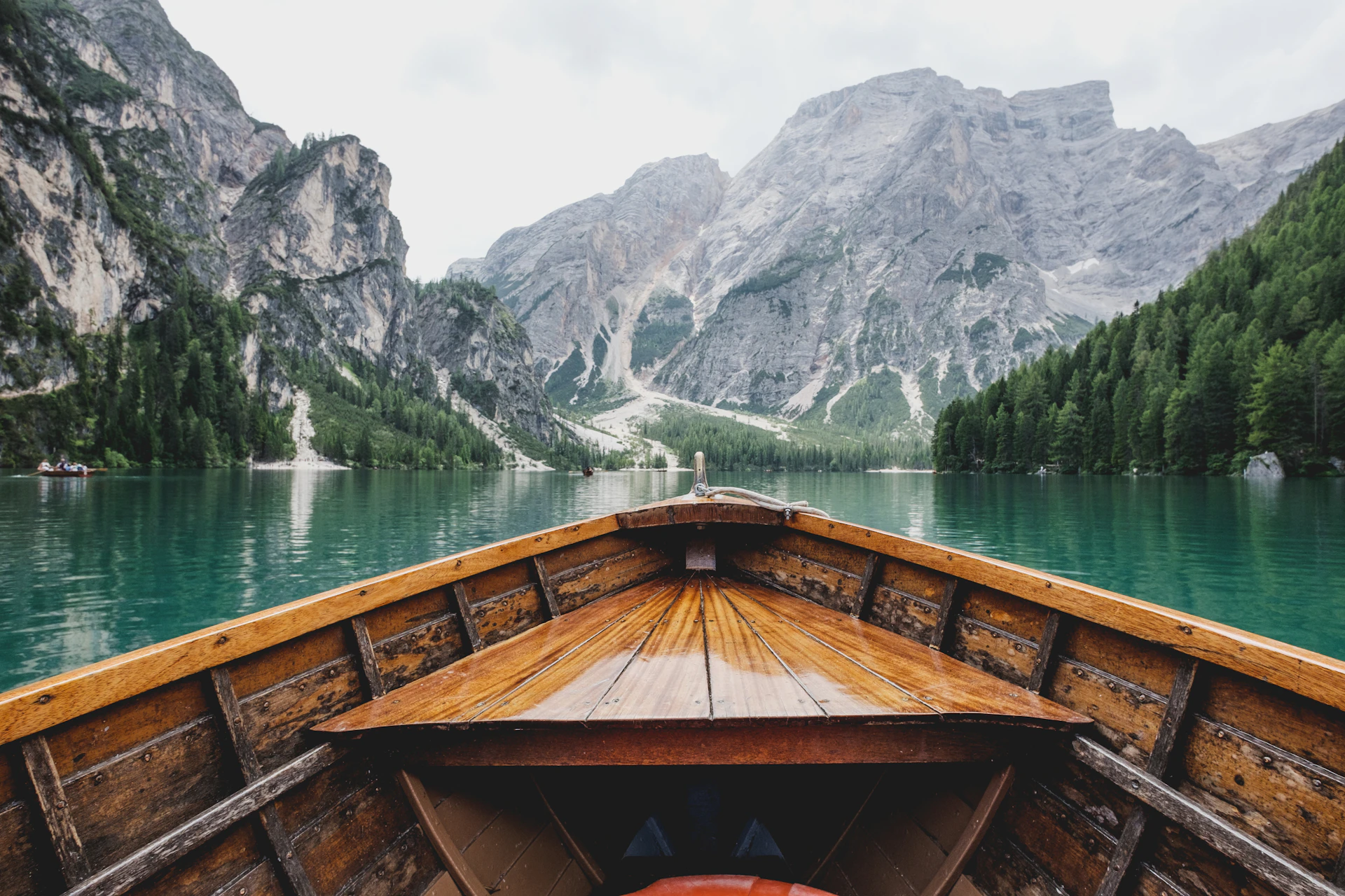 A wooden boat on a turquoise lake in the Italian Dolomites